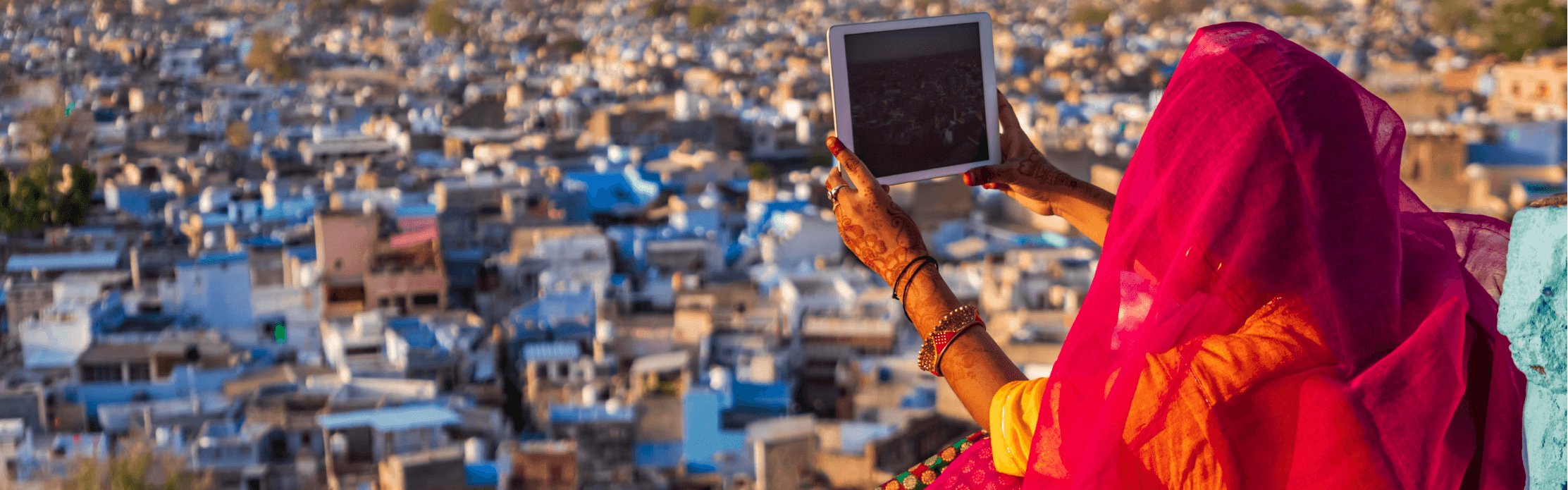 Woman with tablet overlooking city in India